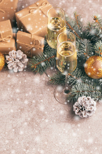 工艺礼品盒，酒杯和圣诞装饰圣诞树树枝和锥在石板大理石背景与雪效果。横向观察。复制空间。