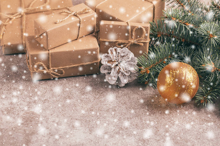 工艺礼品盒和圣诞装饰圣诞树树枝和圆锥在石板大理石背景与雪效果。横向观察。复制空间。