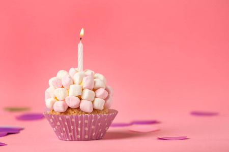 美味的生日蛋糕，有燃烧的蜡烛和棉花糖的颜色背景