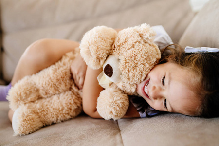 可爱的小女孩在玩她最喜欢的玩具泰迪熊