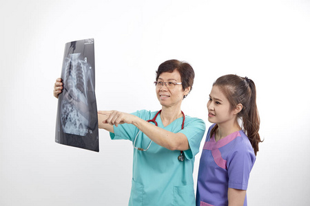 女医生和护士在灰色背景下看X光