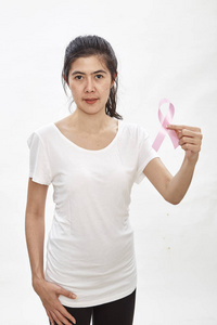 一位身穿白色T恤胸前缀有缎子粉丝带的女士支持乳腺癌意识的象征