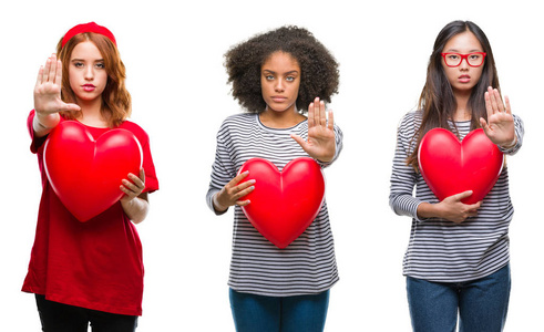 年轻女性用张开的手在孤立的背景上抱着红色的心做停止标志，严肃而自信的表情防御手势