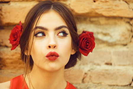 红红的嘴唇和新鲜的玫瑰，在头发的好奇女人