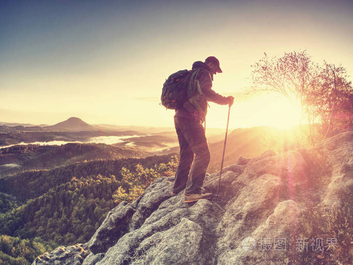 带背包在山上爬山 登山者在山脉鼓舞人心的日出景观中