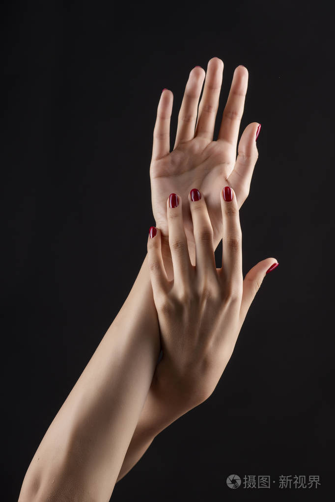 特写漂亮女人的手,指甲上有红色的指甲.