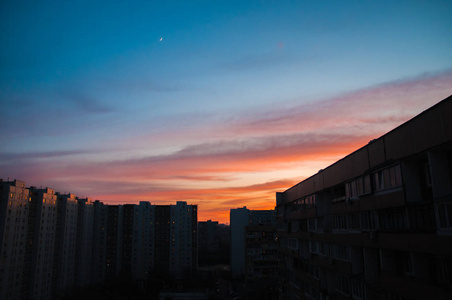 令人愉快的日落和高楼大厦上空的月亮