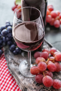 桌上有一杯红酒和葡萄