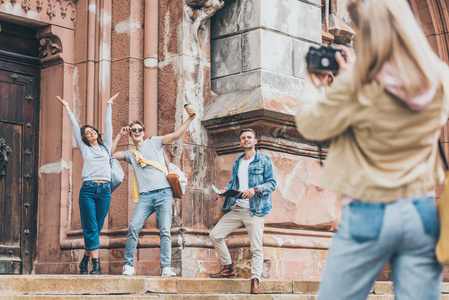 在城市里，女孩用相机拍摄兴奋游客的照片