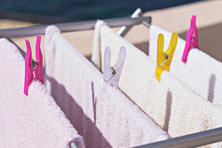 新鲜干净的毛巾在室外洗涤线上干燥。 洗衣房挂在烘干机上。 洗衣服洗作业概念
