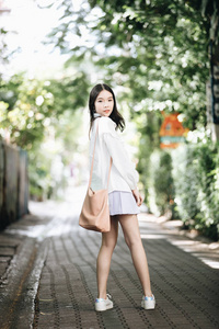 亚洲女孩的肖像，白色衬衫和裙子，看户外城市老式电影风格