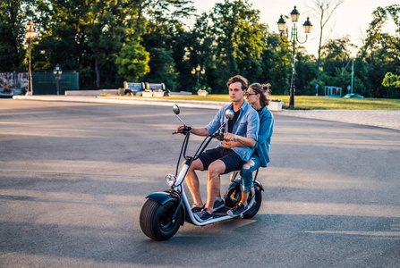 可爱的年轻快乐夫妇驾驶电动自行车