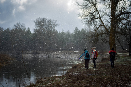 第一次下雪时，一群徒步旅行者沿着河走