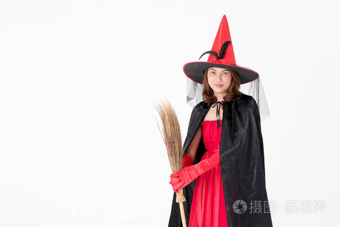 女人穿着红色的服装为著名的女巫拿着扫帚看着相机工作室拍摄的白色