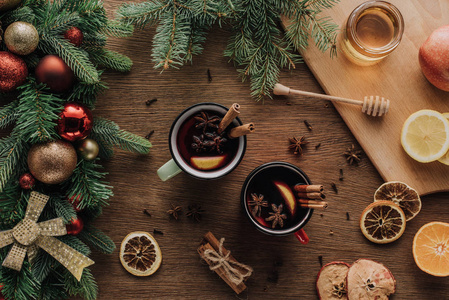 木制桌面上的圣诞概念，上面可以看到杯子上覆盖的葡萄酒和冷杉树枝上的鲍布