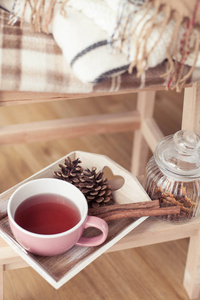 格子呢。 一杯热茶。 秋天舒适的内部。 在木椅上是一叠温暖的毯子。 蜡烛留下锥形篮子肉桂。 书和眼镜。 秋天。