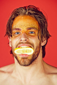 有创意的时尚化妆的人在笑脸上，把柠檬水果放在嘴里，红色背景，美容和时尚过敏保健，维生素素食和节食。
