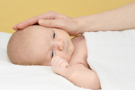 可爱的新生儿，躺在白色毯子上的男婴和手