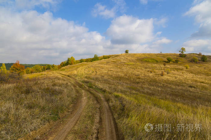秋天的乡村风景. 村郊山丘之间蜿蜒的土路. 五彩缤纷的秋天乡村风光.