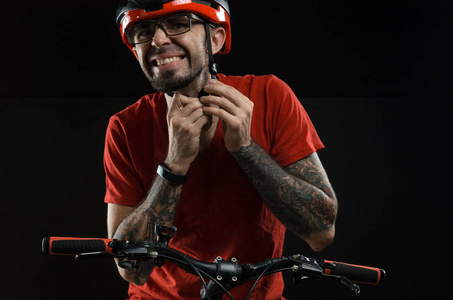 男子在头盔和眼镜在自行车上摆在黑色背景