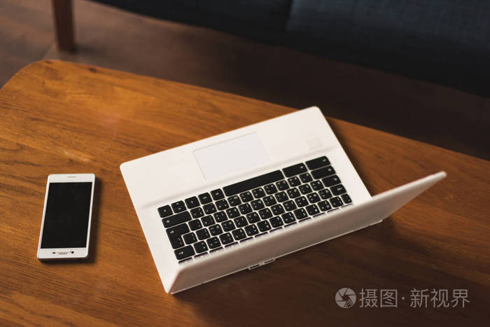 笔记本电脑和智能手机放在桌子上,没有人在家工作的概念