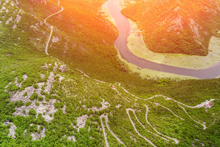 在阳光明媚的日子里，山上蜿蜒的道路和河流的顶部景色