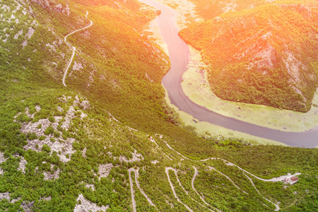 在阳光明媚的日子里，一条蜿蜒的公路和山上的河流的顶部景色