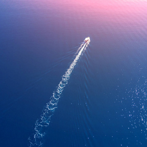 一艘白色的小船在阳光下驶向蔚蓝的大海