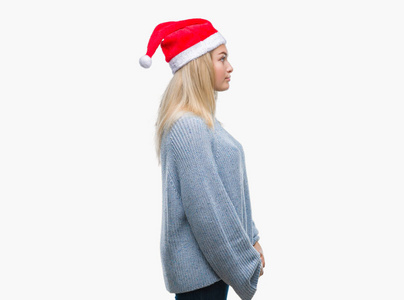 年轻的高加索女人戴着圣诞帽，在孤立的背景下，看着侧面放松的轮廓，自然的脸，自信的微笑。
