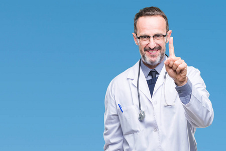 中年高级胡里医生男子穿着医疗制服，孤立的背景显示和指向第一手指，同时微笑自信和快乐。