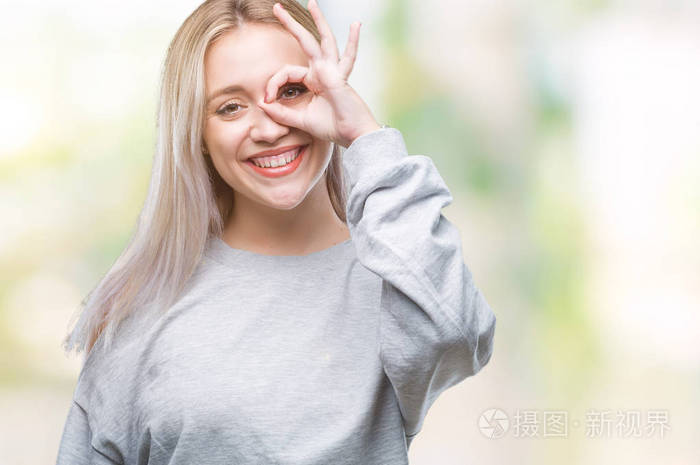 年轻的金发女人在孤立的背景下做好手势,用手微笑的眼睛透过手指看着