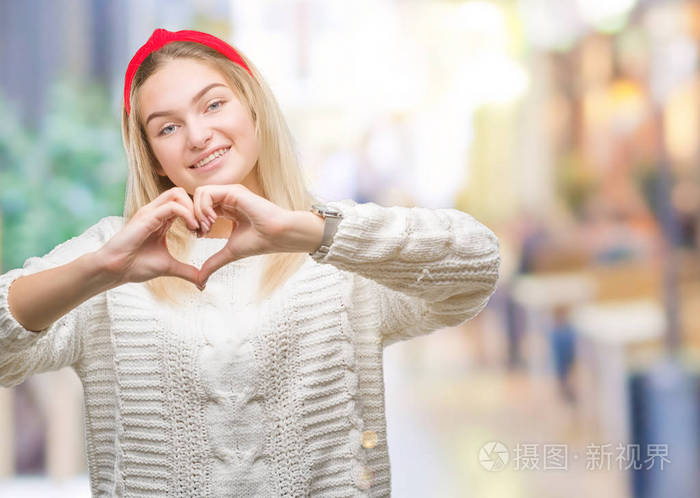 年轻的白种人女人穿着冬天的毛衣,在孤立的背景上微笑,在爱中显示出
