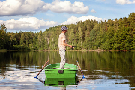一个渔夫正在美丽的湖上乘一艘木船捕鱼