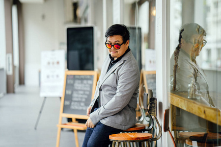 一位穿灰色西装黑色衬衫和太阳镜的中国亚裔男子的肖像智能休闲。 3.他穿着一身时髦的休闲装，自信冷静英俊