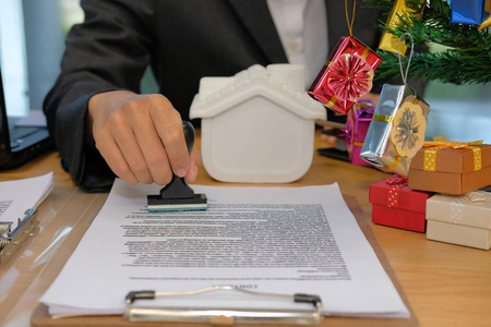 房地产经纪人使用stamper在圣诞节期间抵押贷款合同协议文件上加盖印花