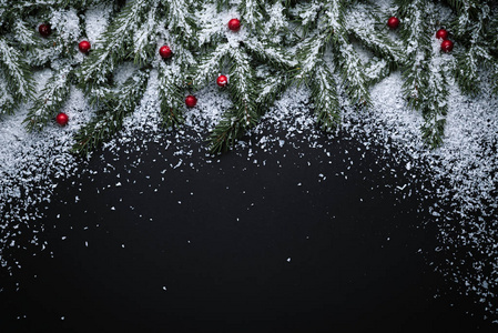 圣诞节假期背景与文本复制空间。 新年装饰与冷杉枝和冬青浆果在雪。 平躺式顶部视图