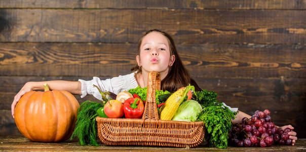 女孩孩子乡村风格农民市场与秋季收获。儿童欢快庆祝收获假日南瓜蔬菜篮。有收获木背景的孩子农夫。收获节概念