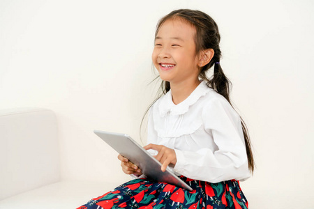带着平板电脑在白色背景上快乐的孩子。童年生活方式。