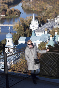 穿着雨衣，戴着墨镜的成熟女人，站在斯维亚托希尔斯克的观景台上