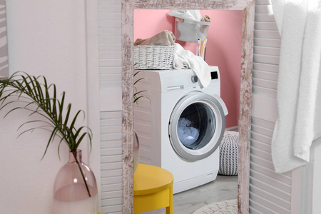 现代洗衣机在家里镜子中的反射。 洗衣房