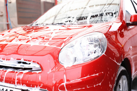 带泡沫的红色汽车洗车服务