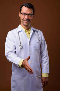 英俊的男人医生的肖像提供握手和微笑