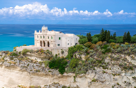 圣玛丽亚戴尔伊索拉修道院圣塔玛丽亚伊索拉教堂，位于泰尔赫尼亚海的岩石之上，绿树蓝天，白云围绕在晴朗的日子里，意大利南部的托