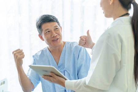 亚洲老年患者在病床上与女医生讨论选择性焦点
