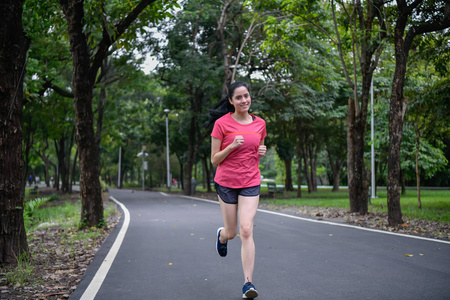 运动概念。 运动女孩在公园里锻炼。 美丽的女孩早上慢跑。