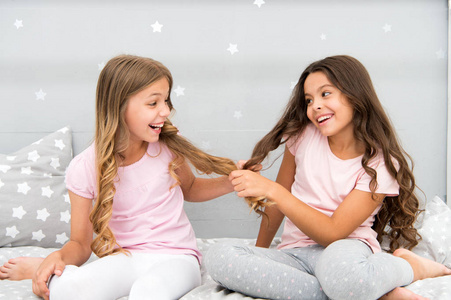 孩子们在卧室里欢快地玩着头发。快乐的童年时刻。孩子们女孩姐妹最好的朋友充满活力在欢快的心情。生长强壮和健康的头发。头发护理的概念