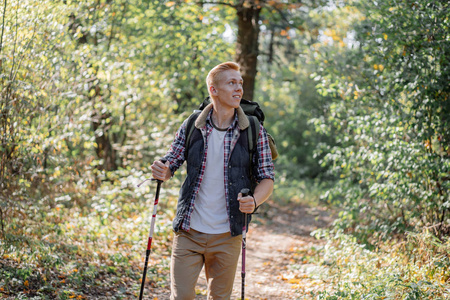 年轻人独自享受徒步旅行与北欧行走棍子在森林