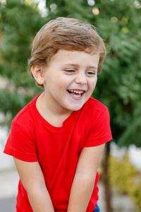 带着红色T恤在花园里玩耍的快乐孩子