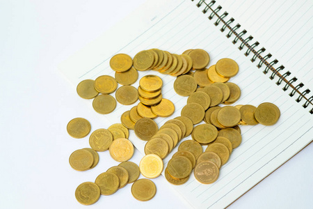一步硬币堆叠在笔记本纸上，复制空间，以增加文本财务和商业规划的概念。