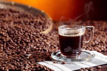 棕色桌子上有咖啡豆的浓缩咖啡杯。
